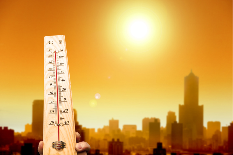 Thermometer in front of a hot city
